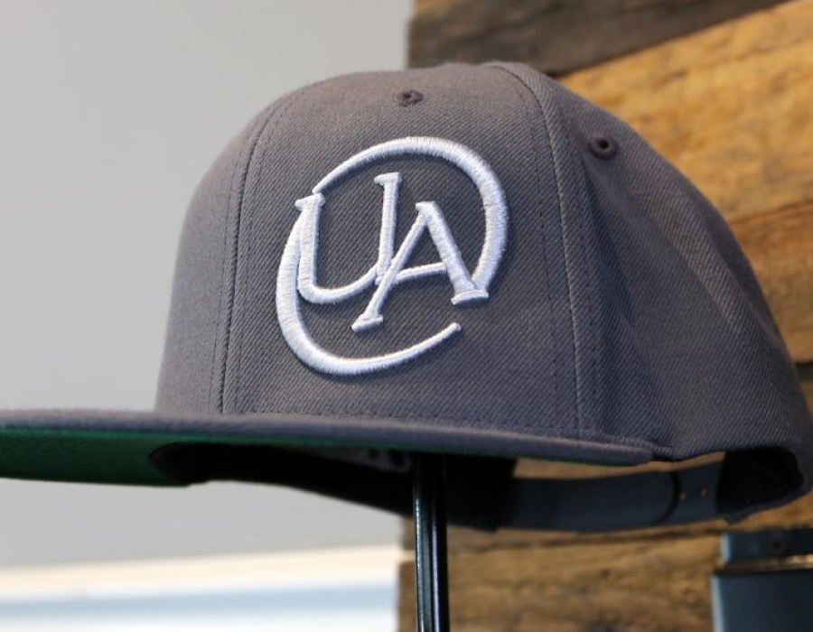 a gray hat with a UA logo