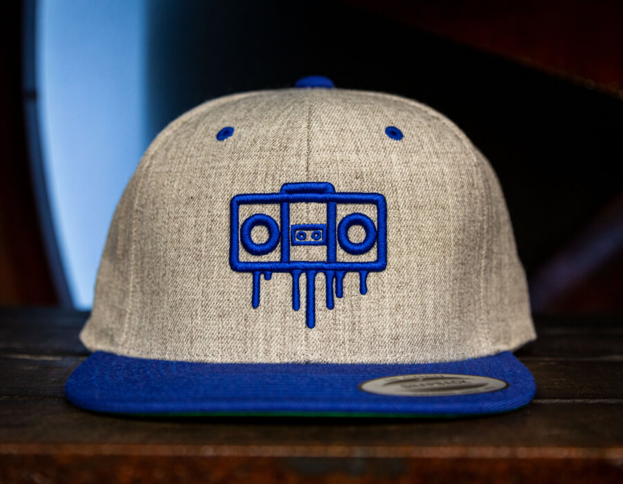 a flexfit style hat with a boom box dripping design
