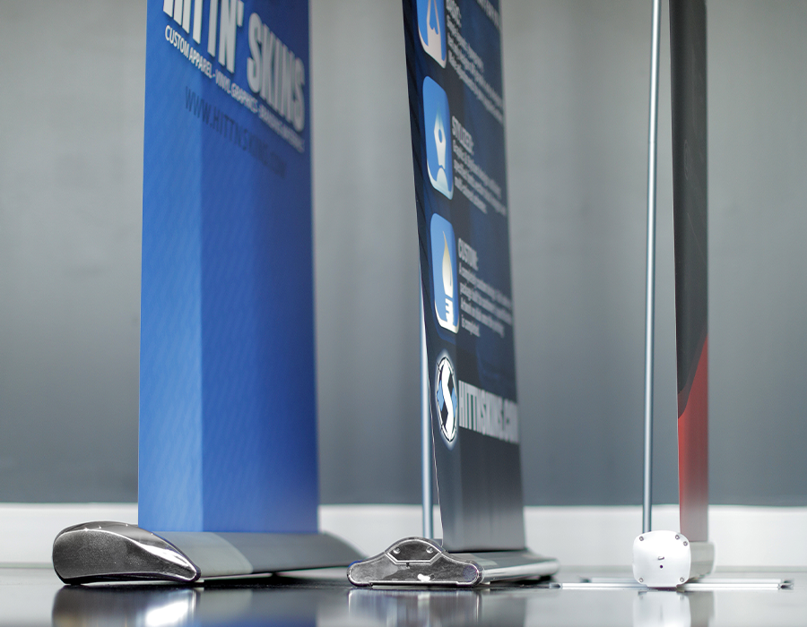 Custom retractable banner stands with multiple base styles and vertical printed graphics for trade shows, events and business displays.