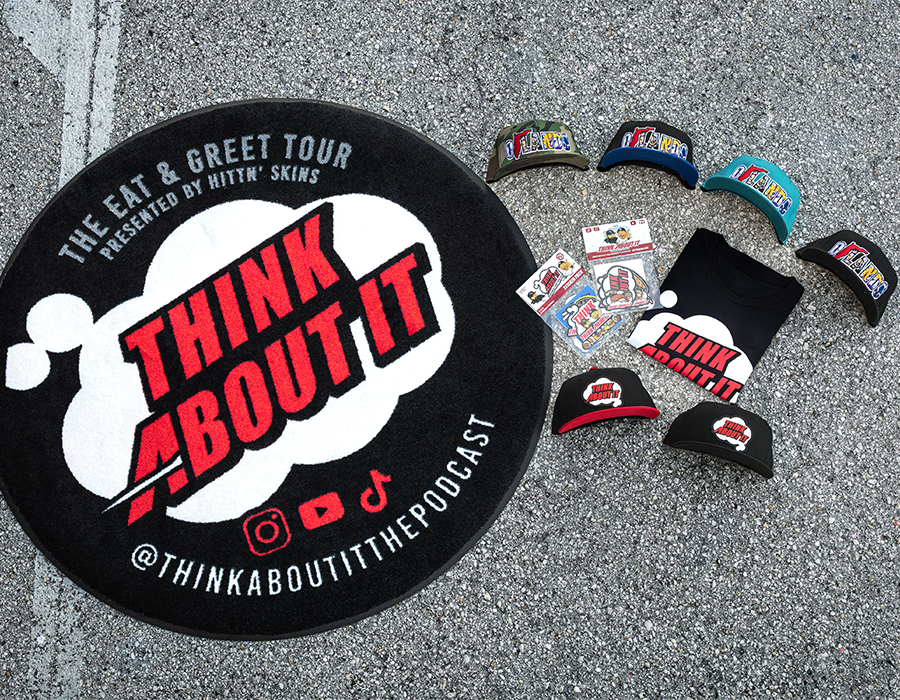 Think About It Podcast custom merch package with screen printed T shirt, branded hats, custom stickers and large round promotional logo rug.