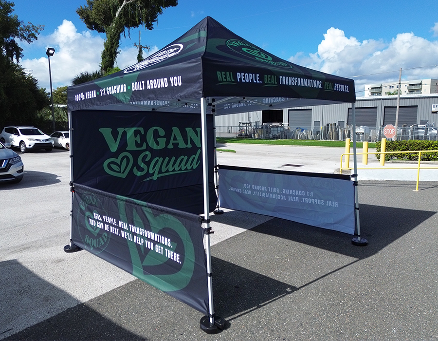 Vegan Squad custom 10x10 event tent with full printed canopy, branded back wall and custom rail skirts for an outdoor vendor booth.